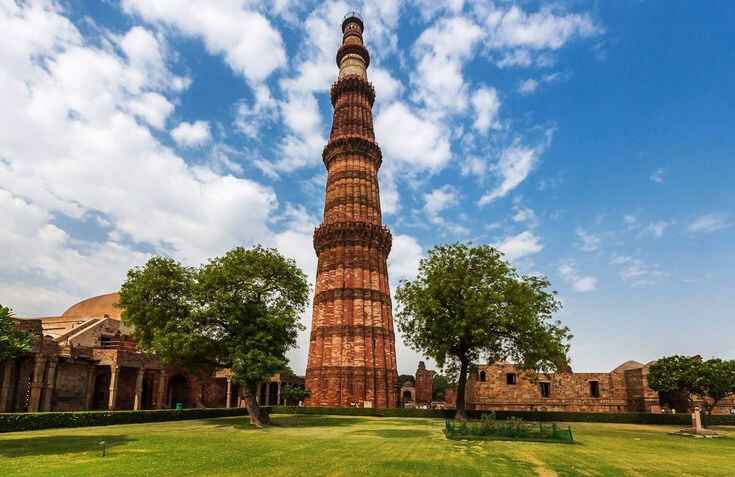 best places to visit in delhi-Qutub Minar is a towering, intricately carved red sandstone minaret in Delhi, rising 73 meters high, surrounded by historic ruins and lush gardens, symbolizing the architectural brilliance of medieval India.